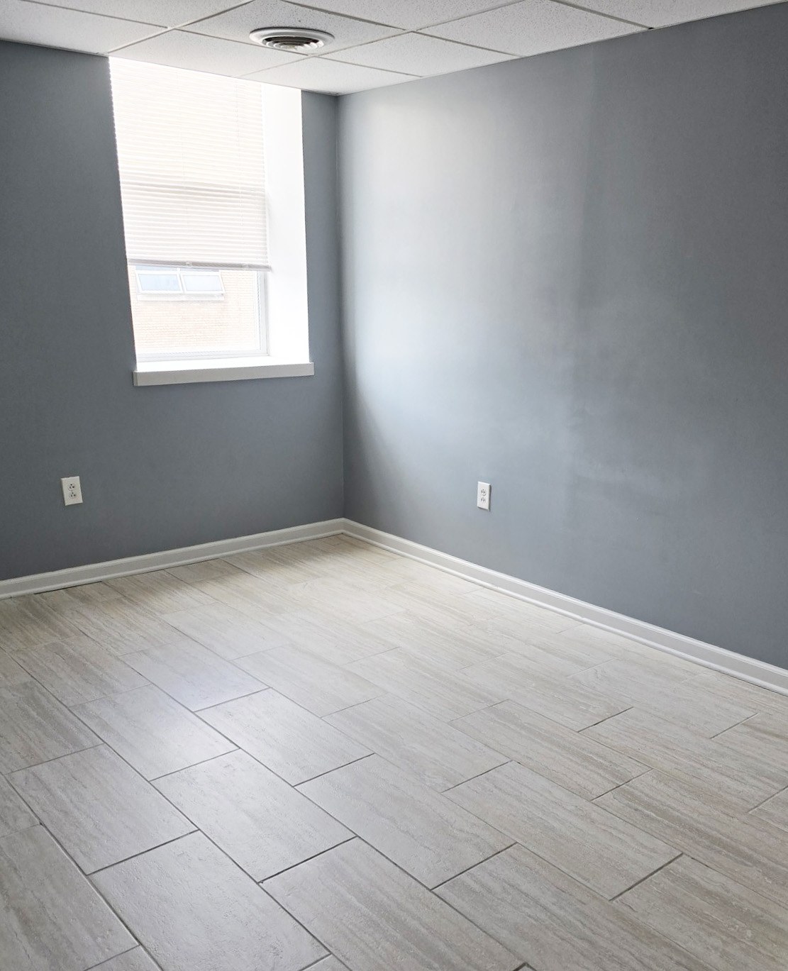 A room with a window and a tile floor.